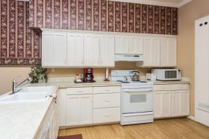 una cocina con armarios blancos y fregadero en Whiskey Row Penthouse, en Prescott