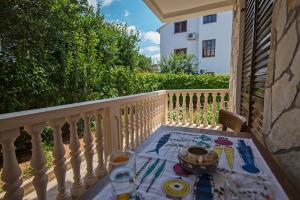 a table on the balcony of a house at Apartments Petrčane Welcome in Petrcane