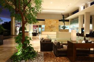 a lobby with couches and a table and a tree at Bahia Principe Luxury Sian Ka´an - Adults Only - All Inclusive in Akumal
