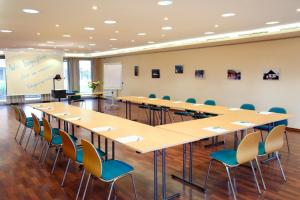 una gran sala de conferencias con una mesa larga y sillas en VCH Hotel Greifswald, en Greifswald