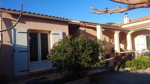 une maison avec une porte blanche et un arbre dans l'établissement Joli villa que du bonheur, à Calenzana