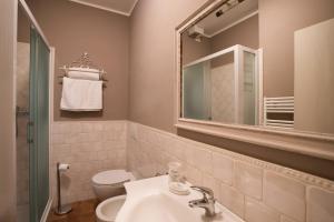 bagno con lavandino, servizi igienici e specchio di Dimora della Rovere a Gradara