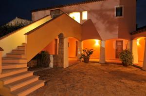 a house with stairs in front of it at night at Hotel Il Piccolo Golf in Porto Cervo