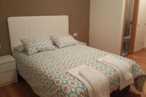 a bedroom with a large bed with a colorful comforter at Piso en la ruta del Románico in Zamora