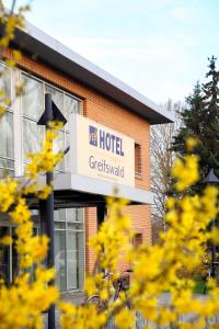 una señal de hotel frente a un edificio de ladrillo en VCH Hotel Greifswald, en Greifswald