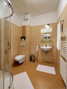 uma casa de banho com um WC, um lavatório e um chuveiro em Melrose Apartments em Bratislava