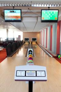 a bowling alley with two lanes and two televisions at VCH Hotel Greifswald in Greifswald