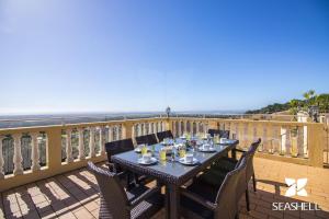 una mesa en un balcón con vistas al océano en Villa Florencio en Estói