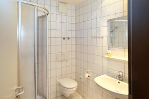 ein weißes Badezimmer mit Toilette und Waschbecken in der Unterkunft VCH Hotel Greifswald in Greifswald