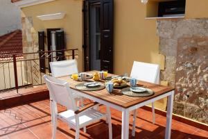 a table with a plate of food on a balcony at Alexandros Traditional House in Ialysos