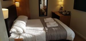a hotel room with a bed with towels on it at The Wellington in Brecon