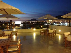 un patio en la azotea con mesas y sombrillas por la noche en Hotel El Brujo Centro Histórico, en Trujillo
