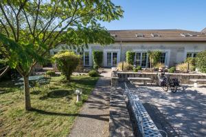 Biały dom z drzewem i ogródkiem w obiekcie Hostellerie De Bretonnière - Groupe Logis Hotels w mieście Beaune