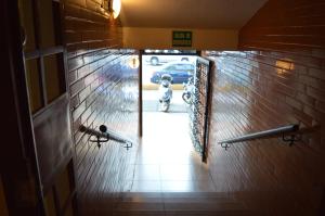 a hallway with a mirror and a parking lot with a car at Hotel Tiburon in Caracas