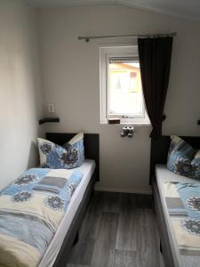 a bedroom with two beds and a window at Ferienhaus MaLeFi 1 am Gülser Moselbogen in Koblenz