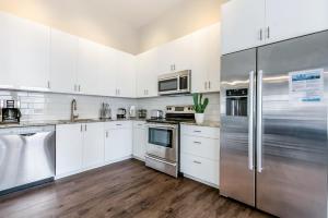 uma cozinha com armários brancos e electrodomésticos de aço inoxidável em 2 Bedroom Elegant condos in Downtown New Orleans em Nova Orleães