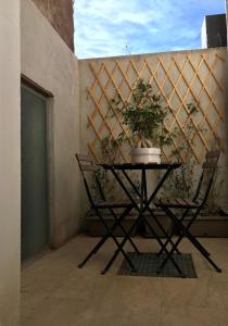 une table et des chaises sur un balcon avec une plante dans l'établissement La Dimora di Medusa, à Catane