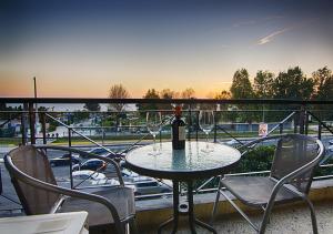 una mesa con una botella de vino y sillas en el balcón en Galaxy Hotel en Atenas