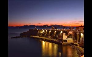 a view of a bridge over the water at night at Casa indipendente Pavolini in Piombino