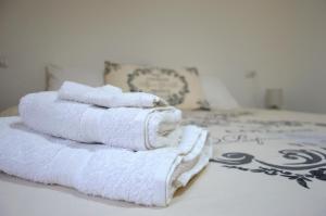 a pile of towels sitting on top of a bed at Mille Soli Bed and Breakfast in Buggerru