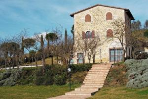 a large stone building with stairs in front of it at Il vecchio seccatoio in Solomeo