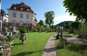 una casa con un patio verde con una pasarela en Hotel Residenz am Rosengarten, en Bad Kissingen