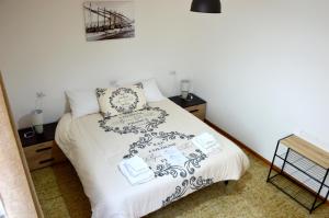 1 dormitorio con 1 cama con sábanas y almohadas blancas en Mille Soli Bed and Breakfast en Buggerru