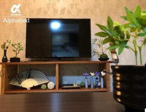 TV de pantalla plana en la parte superior de una estantería de madera en Alphabed Takamatsu Kitahama EAST 202 / Vacation STAY 20102, en Takamatsu
