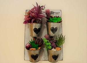 four potted plants in buckets on a wall at Mille Soli Bed and Breakfast in Buggerru