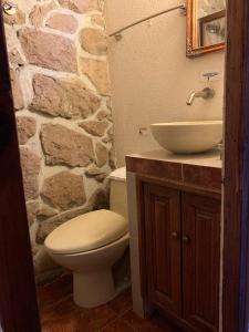 Baño de piedra con aseo y lavamanos en Hotel Casa del Anticuario, en Morelia