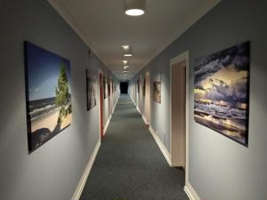 un couloir avec de nombreuses photos sur les murs dans l'établissement Great Polonia Beach & Molo, à Puck