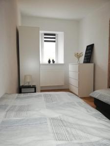 a bedroom with a large white bed and a window at Apartement “Heckeresje“ in Pfungstadt