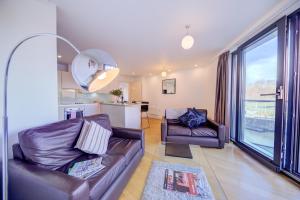 a living room with two leather couches and a kitchen at Cleyro Serviced Apartments - Finzels Reach in Bristol