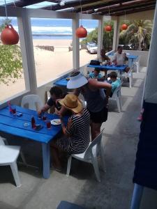 eine Gruppe von Menschen, die am Strand an Tischen sitzen in der Unterkunft Nascer Do Sol - Chizavane in Xai-Xai