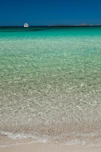a view of the ocean with a boat in the distance at Hotel Il Piccolo Golf in Porto Cervo