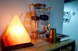 a table with a lamp and a glass jar on it at Mille Soli Bed and Breakfast in Buggerru