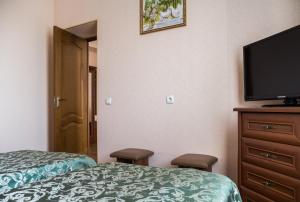 Habitación de hotel con cama y TV de pantalla plana. en Uman Hotel en Umanʼ