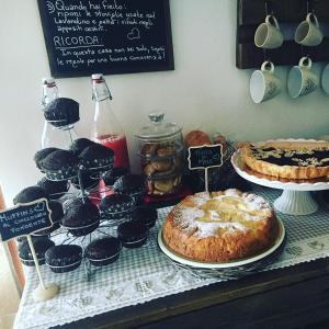 a table with cakes and cupcakes and a table with a cake at Mille Soli Bed and Breakfast in Buggerru