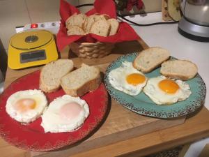 two plates of eggs and bread on a table at Mille Soli Bed and Breakfast in Buggerru