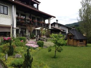 a garden in front of a house with a bird house at Ferienwohnungen Gästehaus Sonnenkreis in Ruhpolding