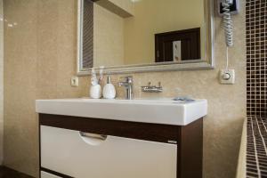 ein Badezimmer mit einem weißen Waschbecken und einem Spiegel in der Unterkunft Uman Hotel in Uman