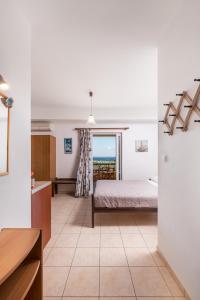 a bedroom with a bed and a view of the ocean at Faros Apartments in Xerokampos