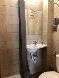W łazience znajduje się umywalka, toaleta i lustro. w obiekcie Galaxy Hotel w Atenach
