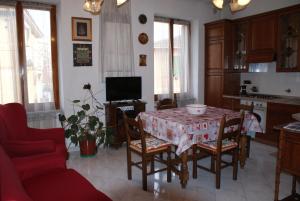 a living room with a table and chairs and a kitchen at Casa Nene in La Spezia