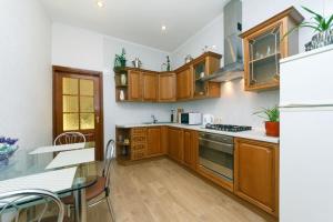 eine Küche mit Holzschränken und einem Tisch darin in der Unterkunft квартира in Kiew