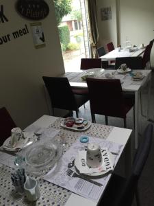 una sala da pranzo con tavoli e sedie e piatti di B&B T Pleintje a Neerpelt