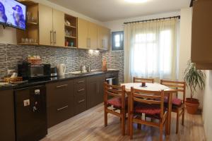 a kitchen with a table and chairs in a kitchen at Central Place Apartment Timisoara in Timişoara