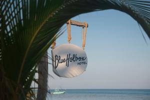 a sign for a beach house hanging from a plant at Blue Holbox in Holbox Island
