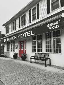 a building with a bench in front of a donation hotel at Dominion Hotel in Minden