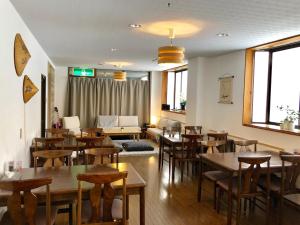 a restaurant with tables and chairs and a couch at Akakura Akarien in Myoko